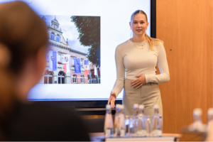 Junge Frau beim Gespräch zur Bewerbung hinter Wasserflaschen